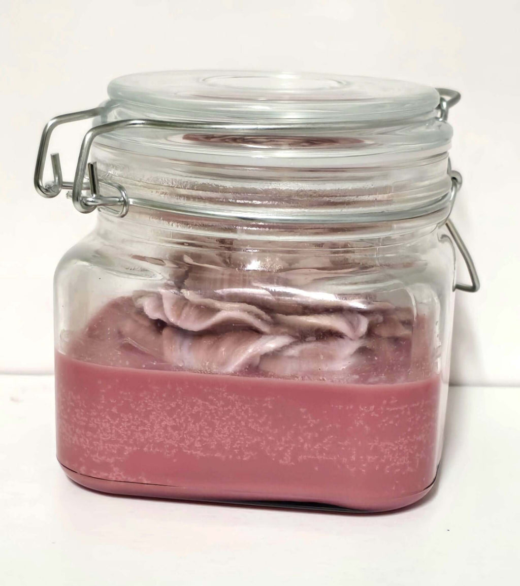 Blueberry Chocolate Scented Candle in a clear glass jar with a metal lid, showcasing its rich color and creamy texture.